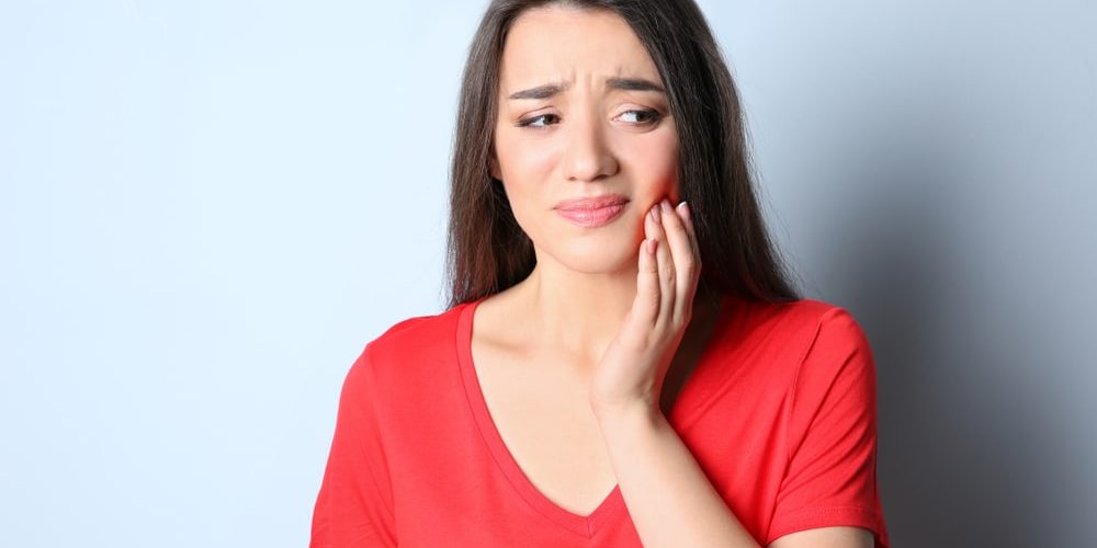 Woman,With,Sensitive,Teeth,On,Color,Background what causes teeth sensitivity