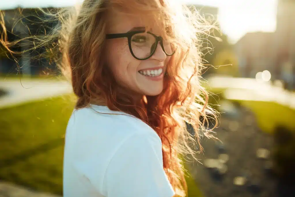 Happy woman with beautiful smile outdoors after professional teeth whitening treatment