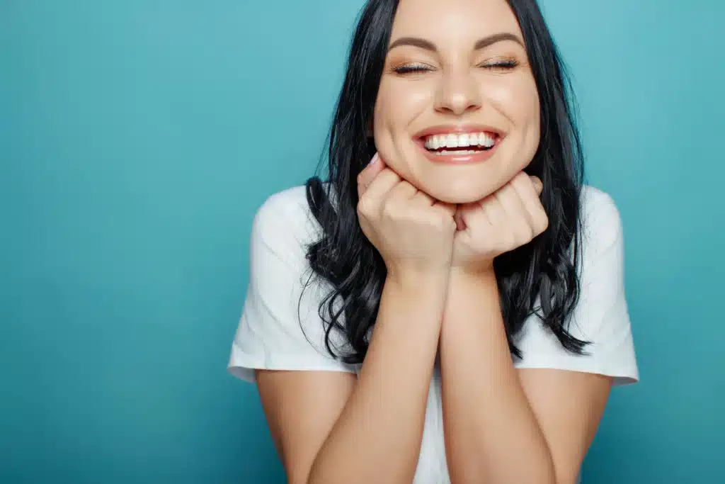 Woman smiling brightly with healthy teeth after cosmetic dentistry in Brentwood, CA